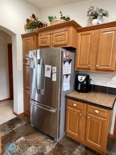 kitchen with dark tile floors and stainless steel fridge