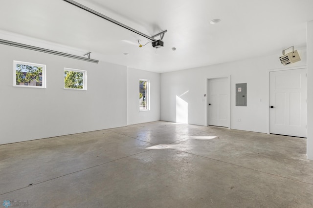 garage with a garage door opener and electric panel