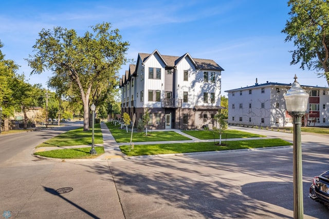 view of front of property featuring a front yard and a balcony