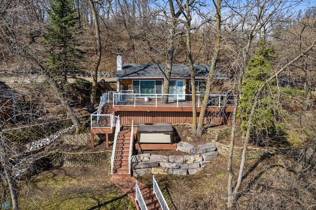 back of house featuring a hot tub and a wooden deck