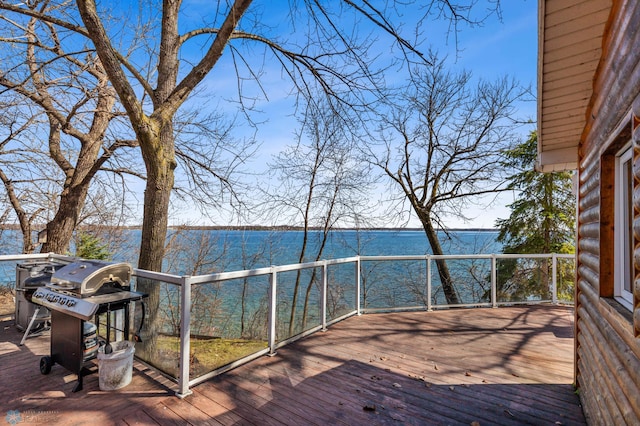 wooden terrace with a water view and area for grilling