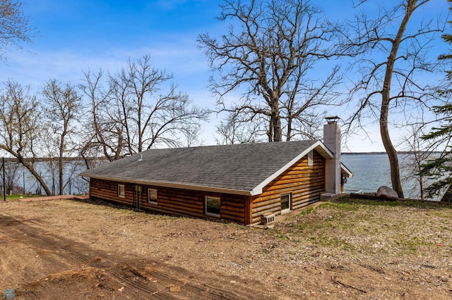 view of side of property featuring central AC unit and a water view