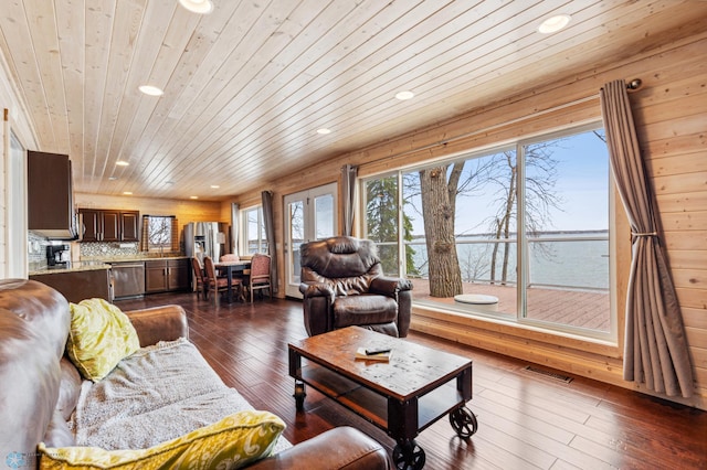 living room with dark hardwood / wood-style floors, wood walls, and wooden ceiling