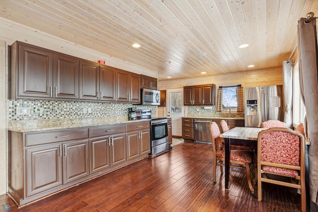 kitchen featuring stainless steel appliances, light stone counters, wood ceiling, and dark hardwood / wood-style floors