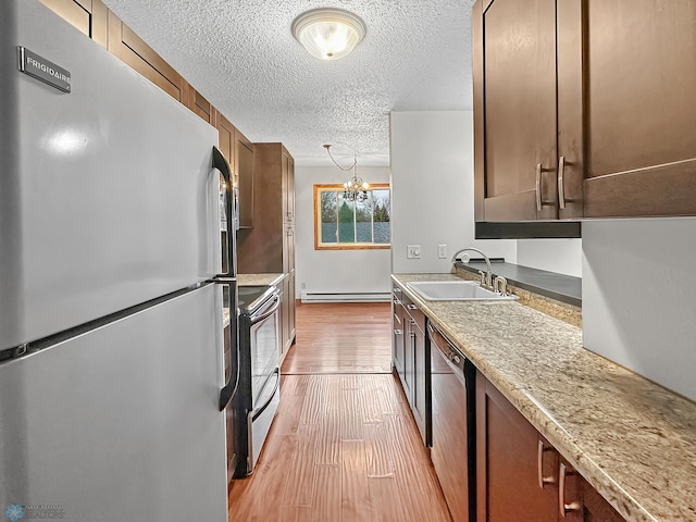 kitchen with black dishwasher, light hardwood / wood-style flooring, electric range oven, refrigerator, and a baseboard radiator