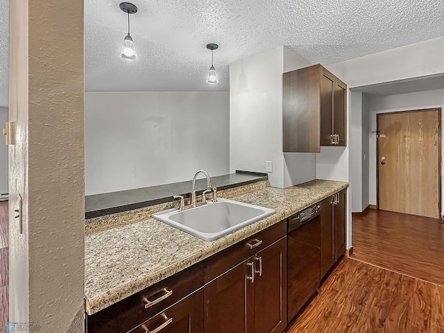 kitchen featuring dark brown cabinets, dark hardwood / wood-style flooring, hanging light fixtures, black dishwasher, and sink