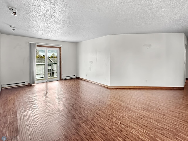 empty room with a baseboard radiator, a textured ceiling, and wood-type flooring