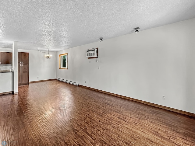 unfurnished living room featuring a notable chandelier, a textured ceiling, a baseboard heating unit, dark hardwood / wood-style flooring, and a wall unit AC