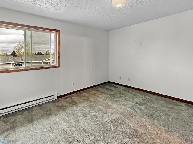 spare room with dark colored carpet, a baseboard radiator, and a textured ceiling