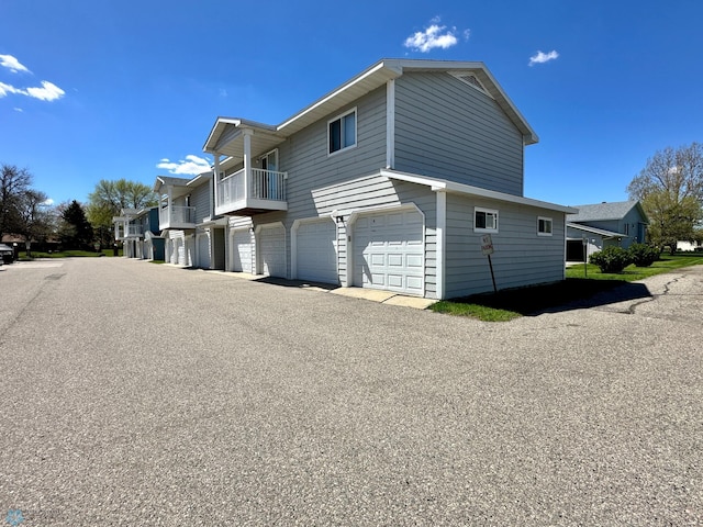 view of home's exterior with a garage and a balcony