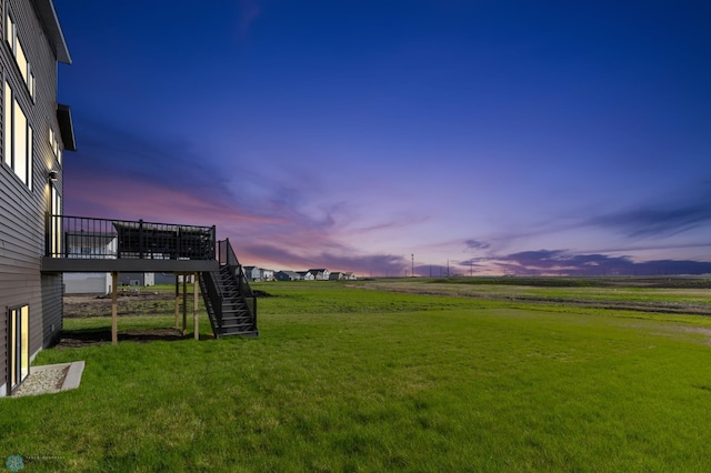 yard at dusk featuring a rural view and a wooden deck