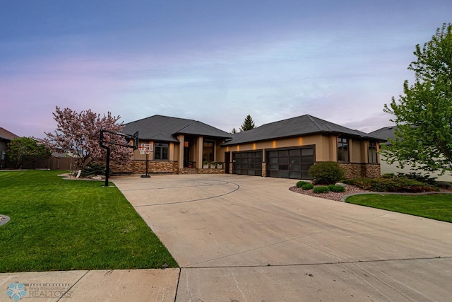 prairie-style house featuring a garage and a lawn