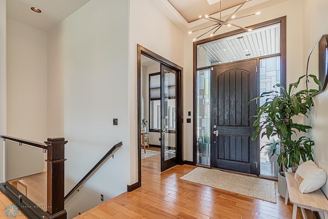 entrance foyer featuring wood-type flooring and a chandelier