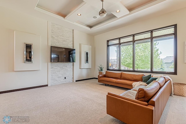 living room with carpet flooring, coffered ceiling, and a tray ceiling