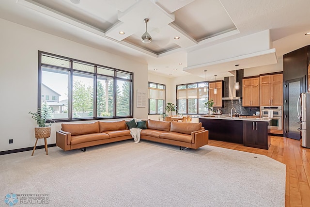 living room with light colored carpet, sink, and coffered ceiling