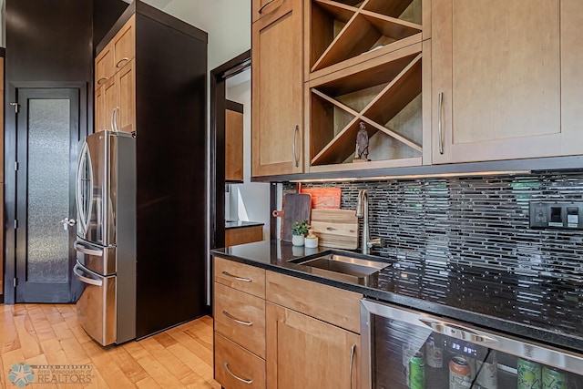 kitchen with stainless steel refrigerator, backsplash, dishwashing machine, light wood-type flooring, and sink