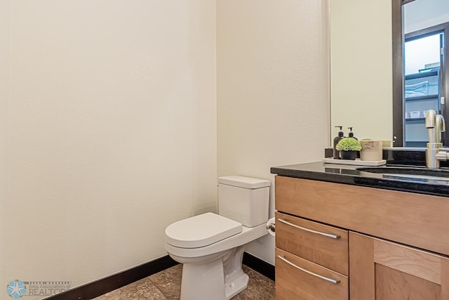 bathroom featuring tile floors, vanity with extensive cabinet space, and toilet