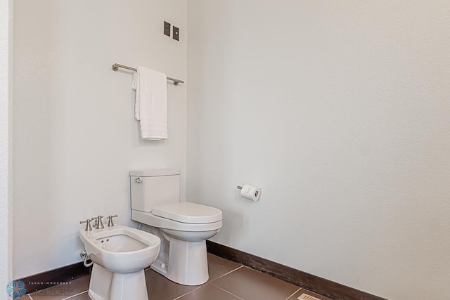 bathroom with a bidet, tile flooring, and toilet