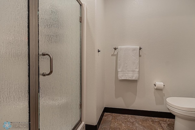 bathroom featuring tile floors, an enclosed shower, and toilet