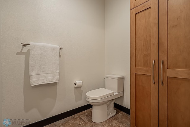 bathroom featuring tile flooring and toilet