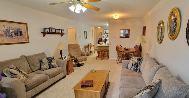 carpeted living room with ceiling fan