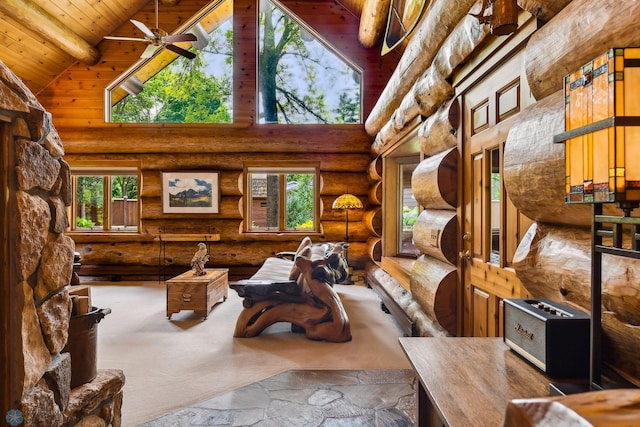 living room with ceiling fan, high vaulted ceiling, wood ceiling, and rustic walls