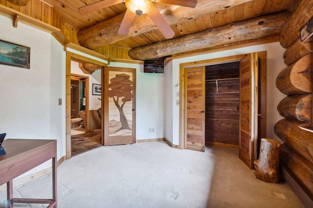 carpeted bedroom featuring ceiling fan, beam ceiling, a closet, and wooden ceiling