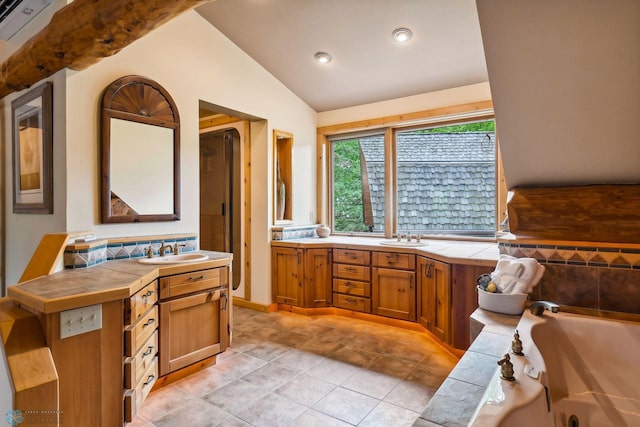 bathroom with tile patterned floors, a bathing tub, lofted ceiling, and double vanity