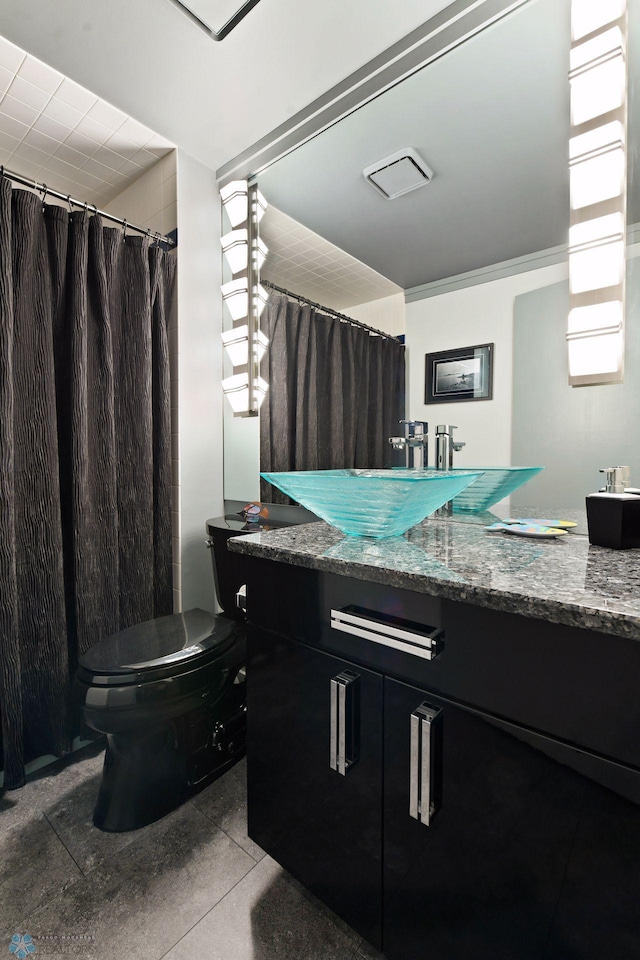 bathroom featuring toilet, ornamental molding, and vanity