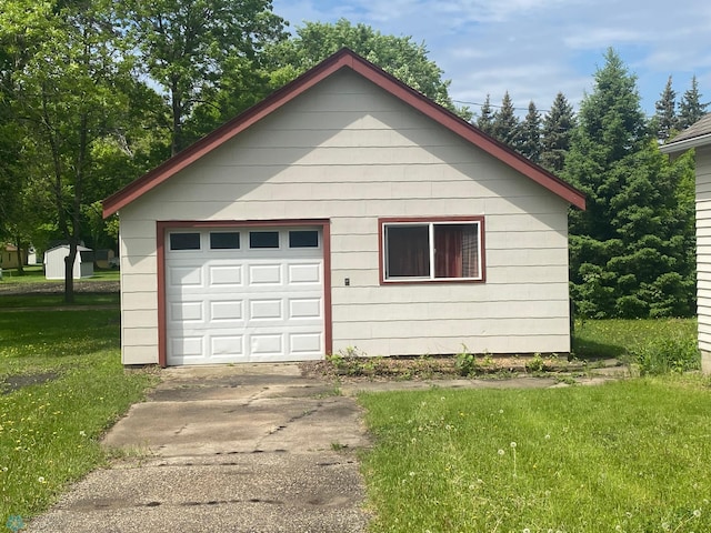 view of front of home with a front lawn, a garage, and an outdoor structure