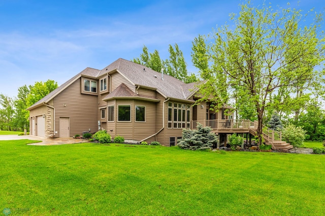 back of house featuring a wooden deck, a garage, and a lawn