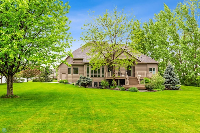 rear view of house featuring a yard and a wooden deck