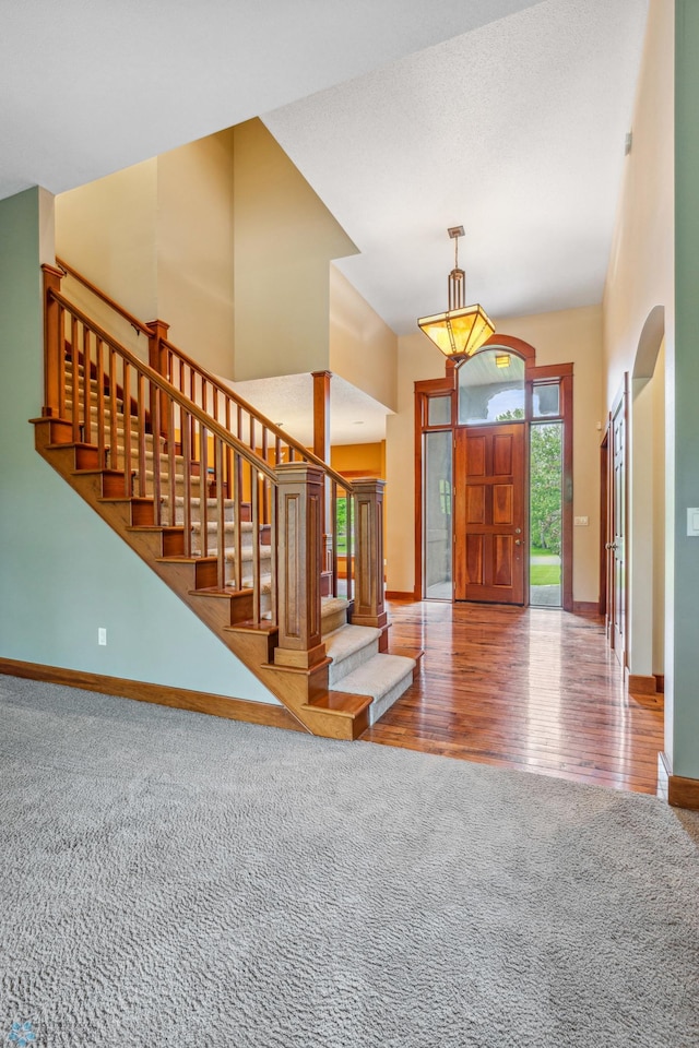 carpeted foyer featuring a high ceiling