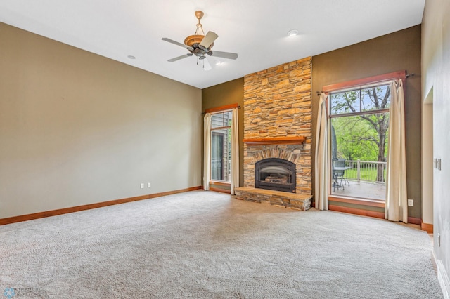 unfurnished living room featuring a stone fireplace, ceiling fan, and carpet floors