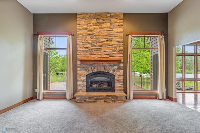 unfurnished living room featuring carpet flooring and a stone fireplace