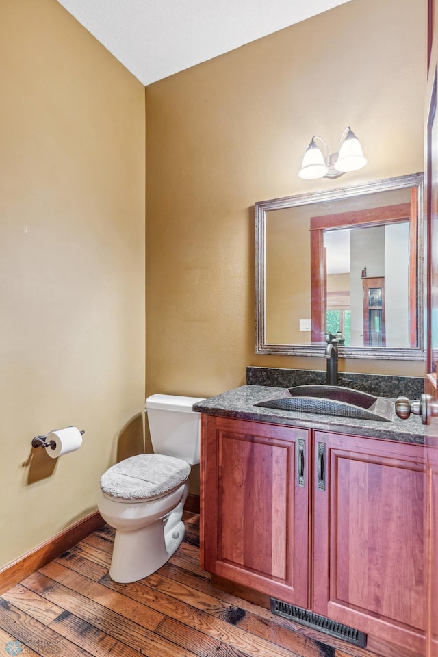 bathroom with hardwood / wood-style floors, vanity, and toilet