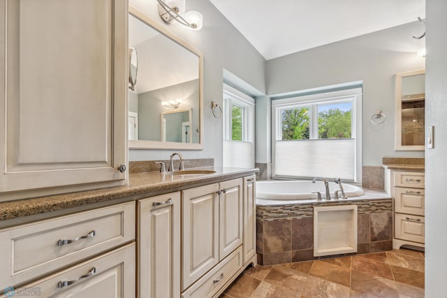 bathroom featuring a relaxing tiled bath, tile flooring, and vanity