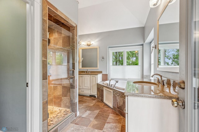 bathroom with shower with separate bathtub, vaulted ceiling, vanity, and tile floors