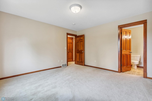 unfurnished bedroom with light colored carpet and ensuite bath