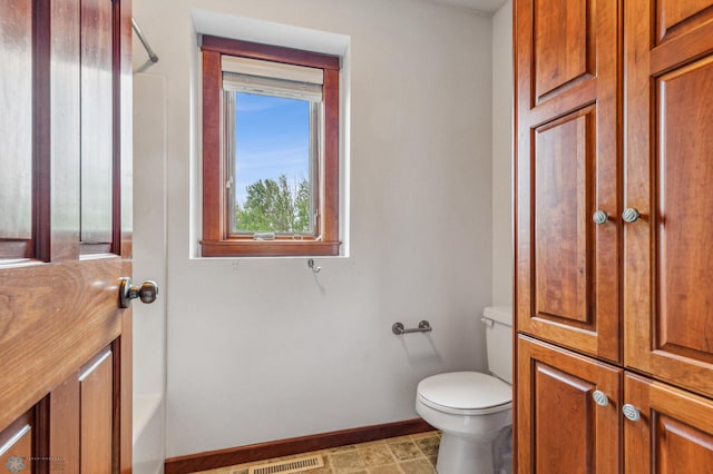 bathroom with tile floors, shower / bathing tub combination, and toilet