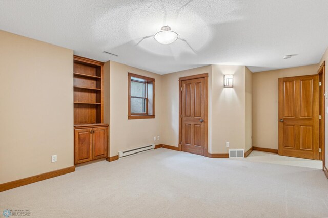 unfurnished bedroom featuring a baseboard heating unit, light carpet, and a textured ceiling