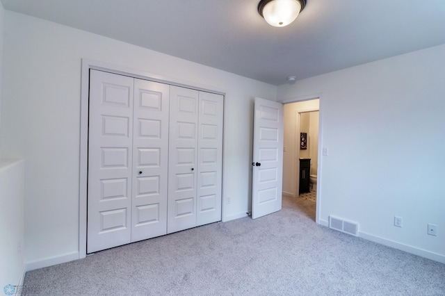 unfurnished bedroom featuring carpet flooring and a closet