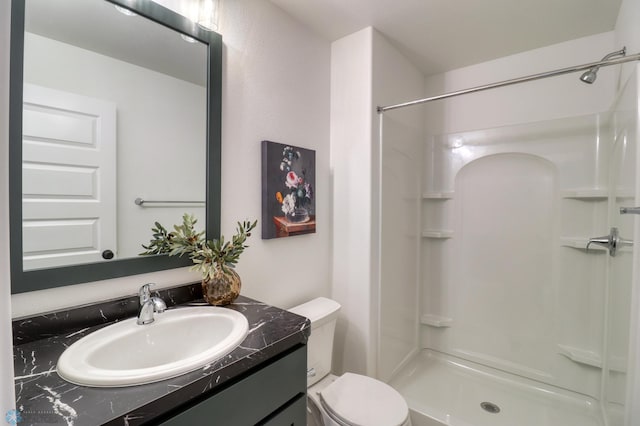 bathroom with oversized vanity, toilet, and a shower