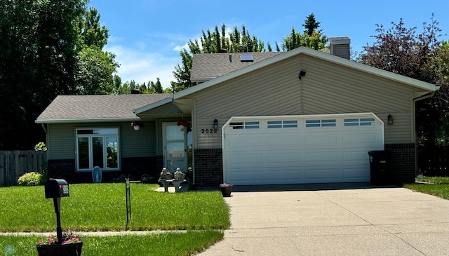 ranch-style house featuring a front yard and a garage