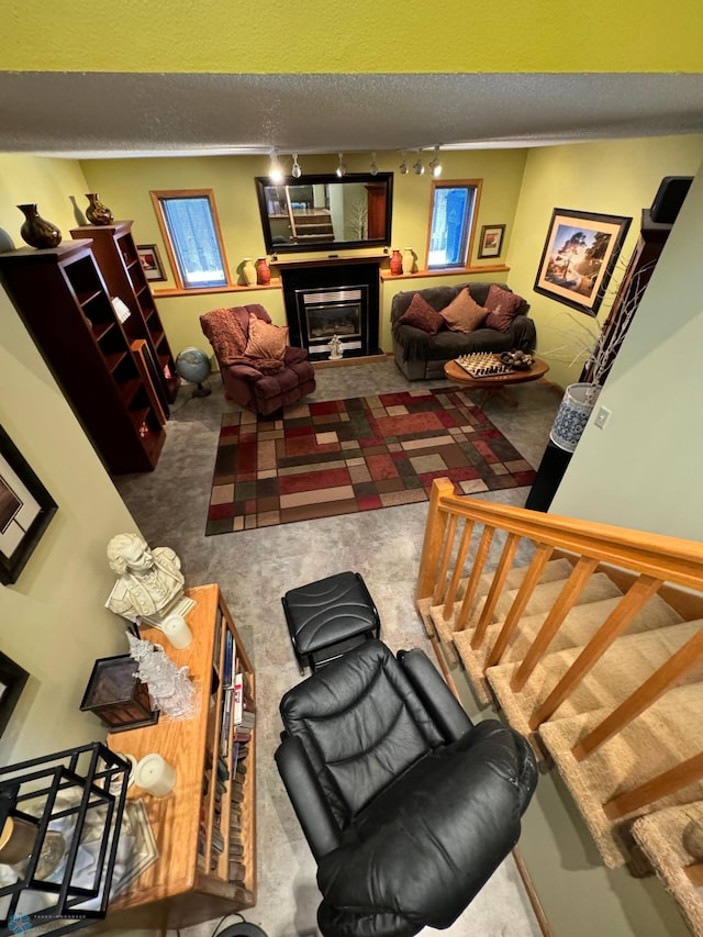 carpeted living room with track lighting, crown molding, and a textured ceiling