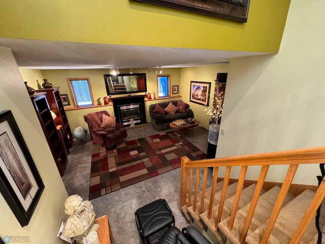 carpeted living room featuring a textured ceiling and track lighting