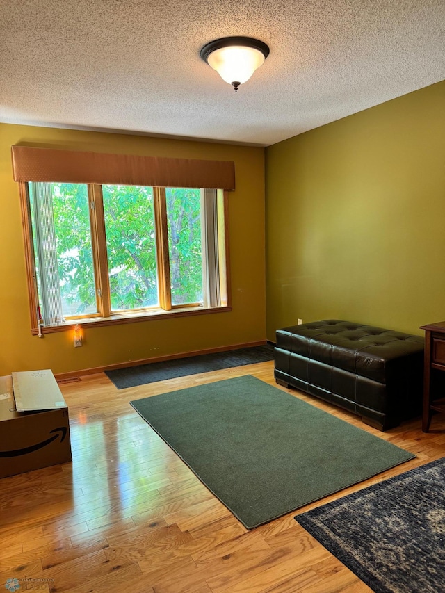 workout area with wood-type flooring and a textured ceiling