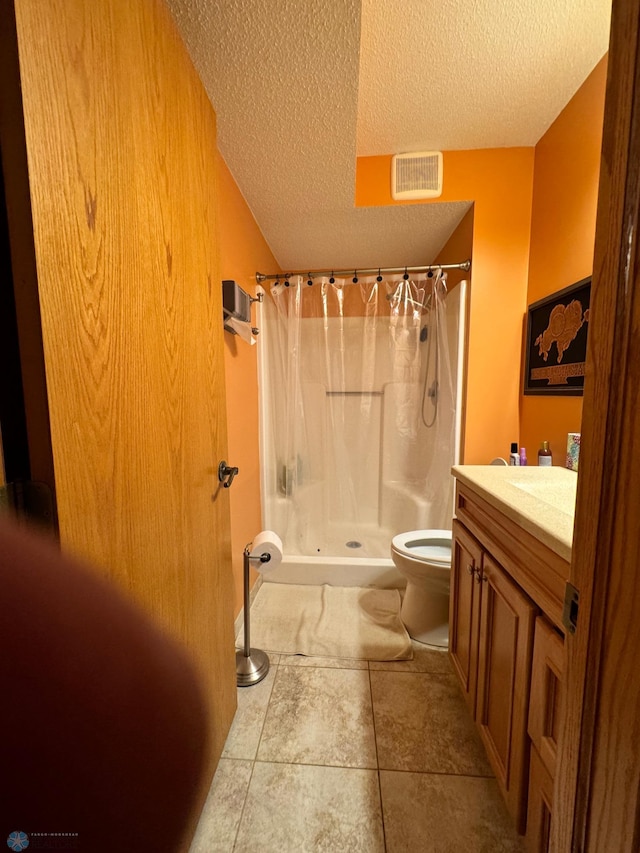 bathroom with tile patterned flooring, walk in shower, toilet, vanity, and a textured ceiling