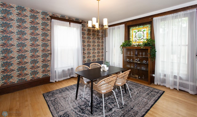 dining space featuring light wood-type flooring and an inviting chandelier