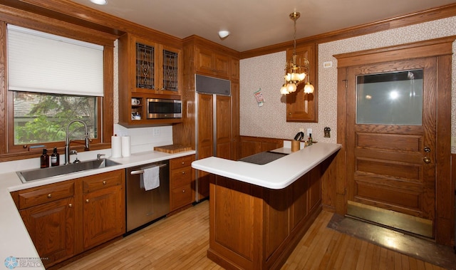 kitchen with sink, light wood-type flooring, kitchen peninsula, and appliances with stainless steel finishes